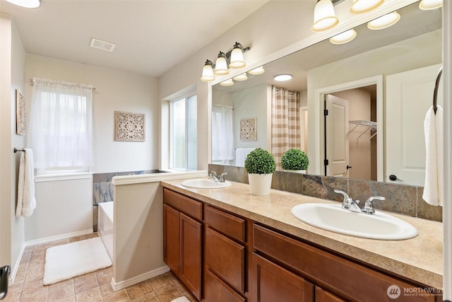 full bathroom with visible vents, plenty of natural light, and a sink