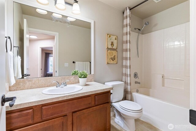 full bathroom with tile patterned floors, shower / bath combo with shower curtain, toilet, and vanity