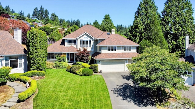 traditional-style house with a front lawn, an attached garage, and driveway