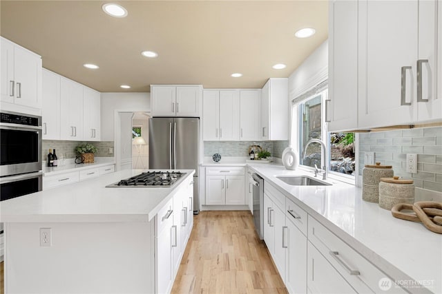 kitchen featuring light countertops, white cabinets, appliances with stainless steel finishes, and a sink