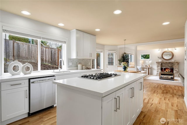 kitchen featuring white cabinets, appliances with stainless steel finishes, a healthy amount of sunlight, and a sink