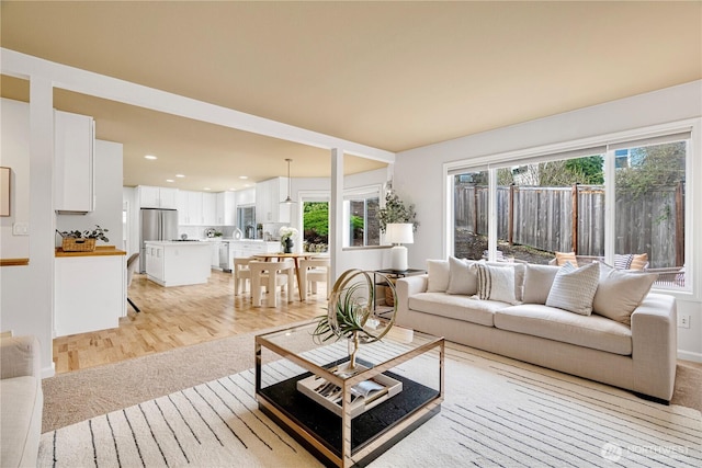 living area featuring recessed lighting, plenty of natural light, and light wood-style flooring