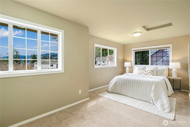 carpeted bedroom featuring baseboards and attic access