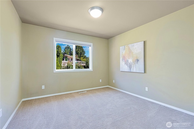 carpeted empty room with visible vents and baseboards