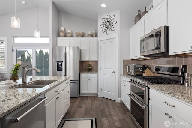 kitchen featuring lofted ceiling, dark wood-style flooring, a sink, white cabinetry, and appliances with stainless steel finishes