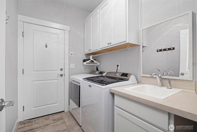 washroom featuring washer and clothes dryer, a sink, and cabinet space