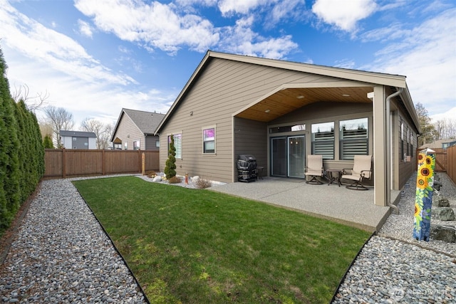 back of property featuring a yard, a patio area, and a fenced backyard