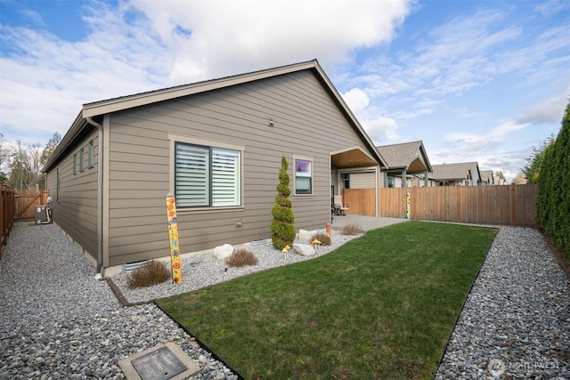 exterior space with a patio area, a fenced backyard, and a lawn