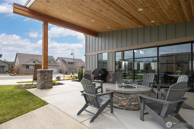 view of patio / terrace with an outdoor fire pit, a residential view, and grilling area