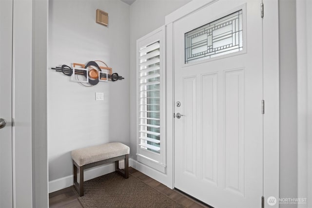 foyer featuring dark wood-type flooring and baseboards