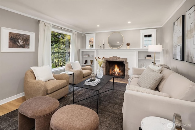 living area featuring a warm lit fireplace, baseboards, wood finished floors, and recessed lighting