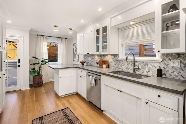 kitchen with dishwasher, a peninsula, light wood-type flooring, white cabinetry, and a sink