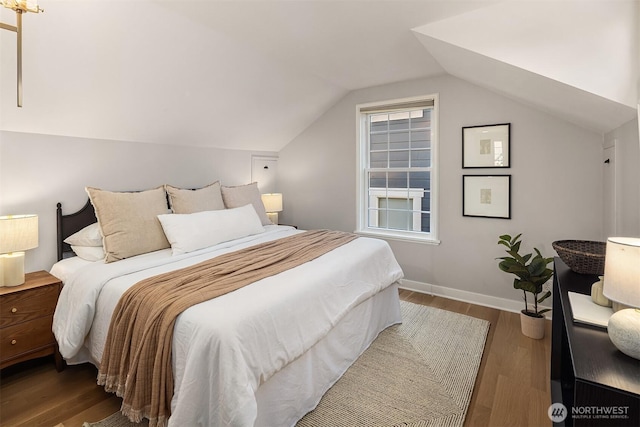 bedroom with lofted ceiling, wood finished floors, and baseboards