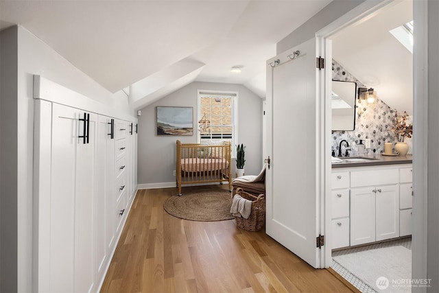 bathroom featuring lofted ceiling, wood finished floors, and vanity