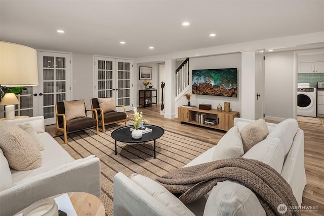 living room featuring french doors, recessed lighting, washer / clothes dryer, light wood-type flooring, and stairs