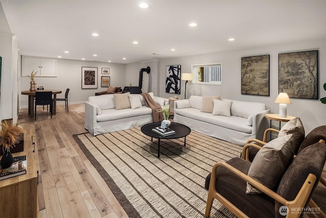 living area with light wood-style floors and recessed lighting