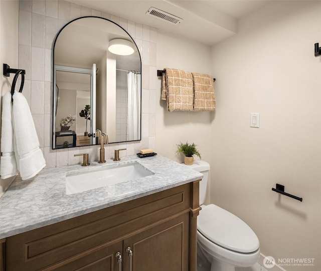 full bathroom featuring toilet, visible vents, and vanity