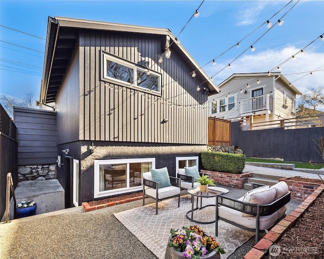 rear view of house with an outdoor hangout area, a patio area, and fence