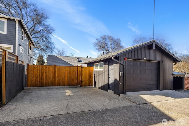 detached garage with a gate and fence