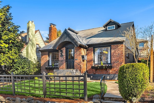 view of front of home featuring brick siding, a fenced front yard, and a front yard