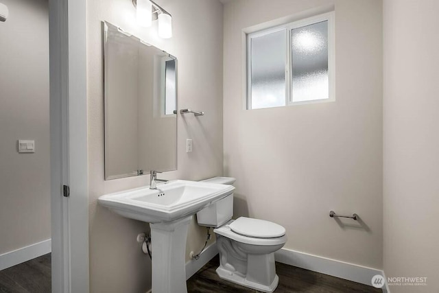 bathroom featuring baseboards, toilet, and wood finished floors