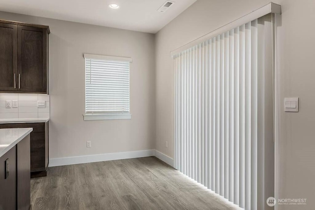 unfurnished dining area featuring recessed lighting, visible vents, baseboards, and wood finished floors