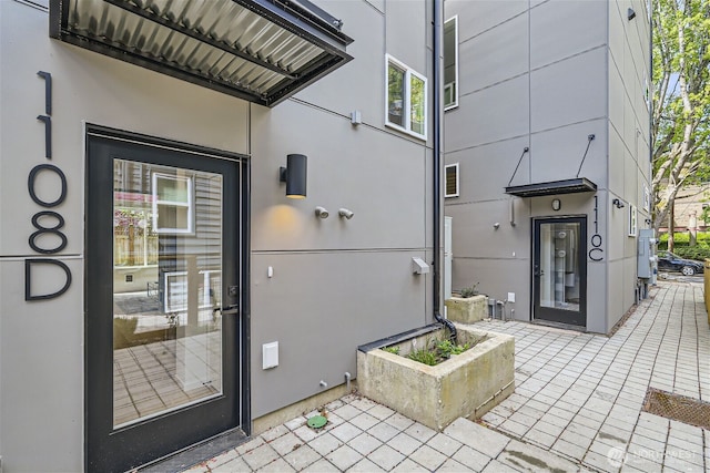 doorway to property featuring stucco siding