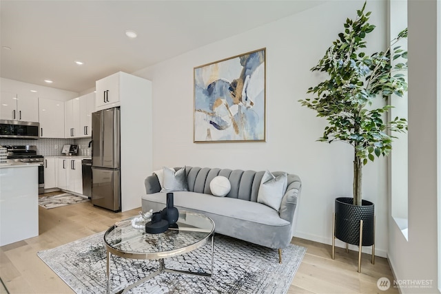 living area with light wood finished floors, baseboards, and recessed lighting