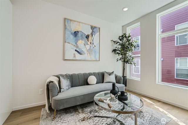 living room with light wood-style floors, baseboards, and recessed lighting