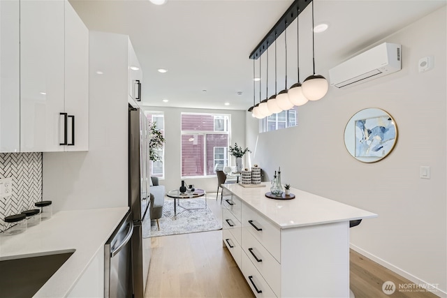 kitchen featuring light wood-style flooring, an AC wall unit, backsplash, and modern cabinets