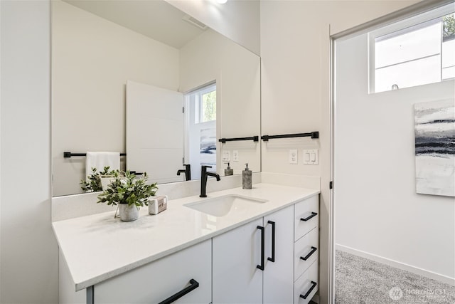 bathroom featuring visible vents, baseboards, and vanity