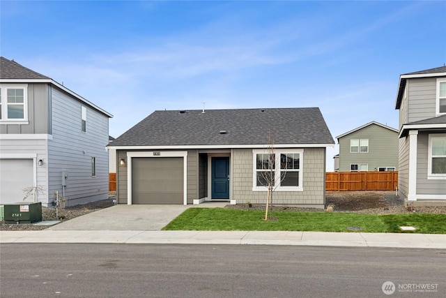 view of front facade with a shingled roof, central AC unit, concrete driveway, an attached garage, and fence