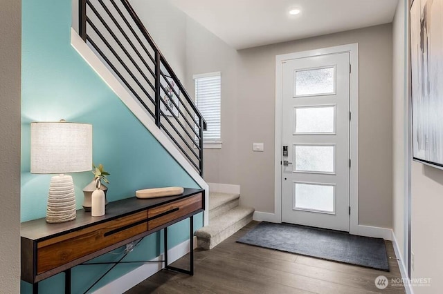 foyer with stairway, dark wood finished floors, and baseboards