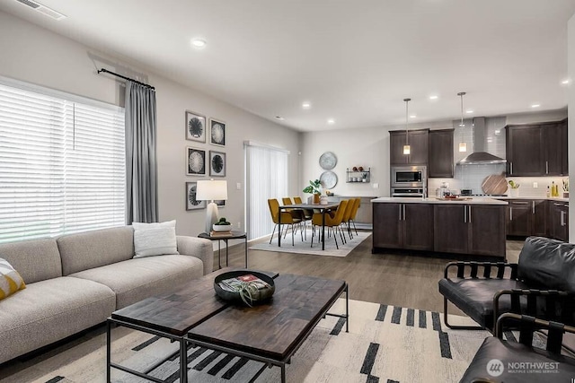 living area featuring recessed lighting, visible vents, and wood finished floors