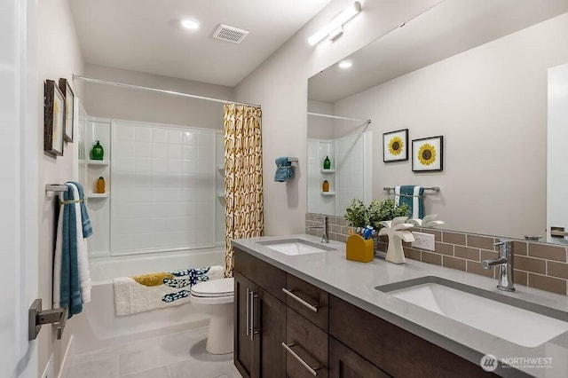 bathroom featuring toilet, tasteful backsplash, visible vents, and a sink