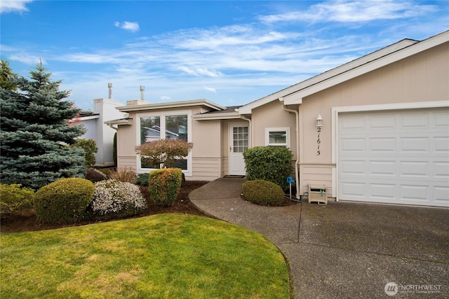 view of front of home featuring a garage, a front yard, driveway, and stucco siding