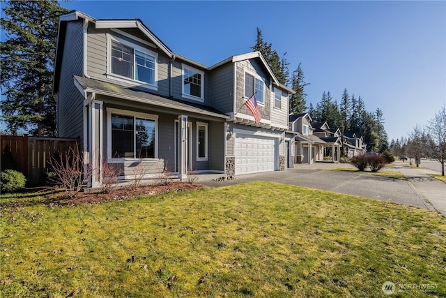 view of front of home with driveway, a front yard, an attached garage, and fence