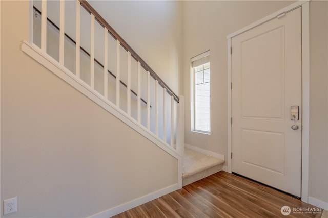 foyer featuring stairway, baseboards, and wood finished floors