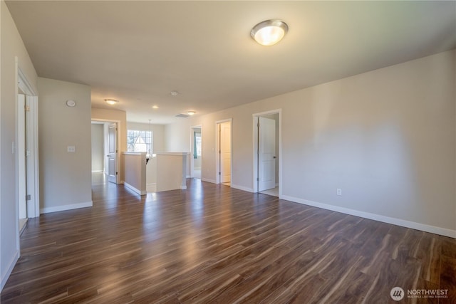 empty room with baseboards and dark wood-style flooring