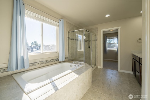 bathroom with vanity, a bath, baseboards, and a stall shower