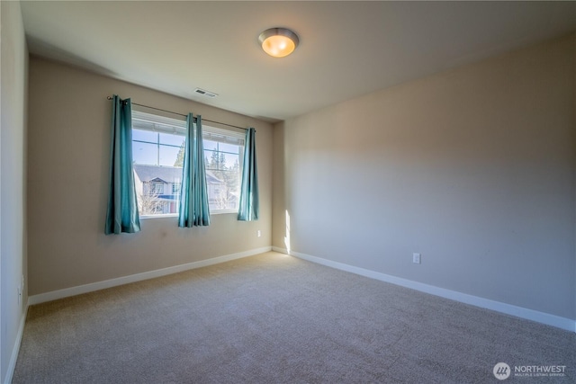 carpeted empty room featuring visible vents and baseboards