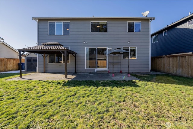 back of property with a patio, a fenced backyard, a gazebo, a storage shed, and a lawn