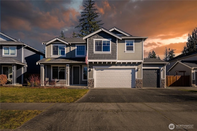 craftsman-style home with stone siding, driveway, a porch, and a front lawn