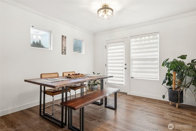 dining room featuring ornamental molding, baseboards, and wood finished floors