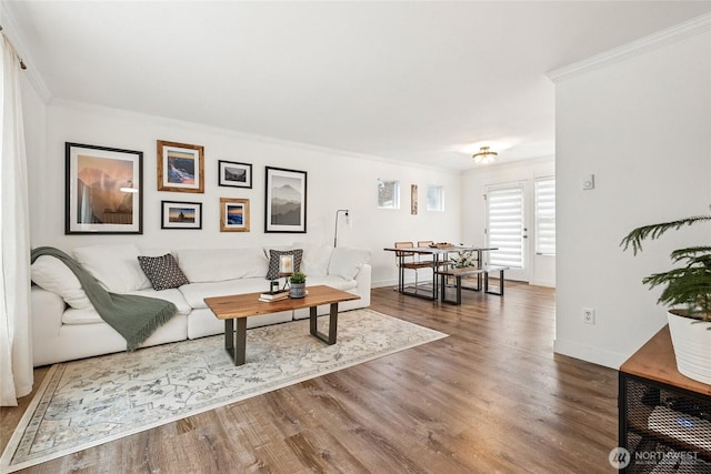 living room with baseboards, crown molding, and wood finished floors