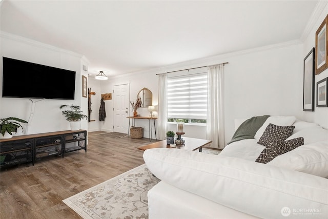 living area with ornamental molding and wood finished floors