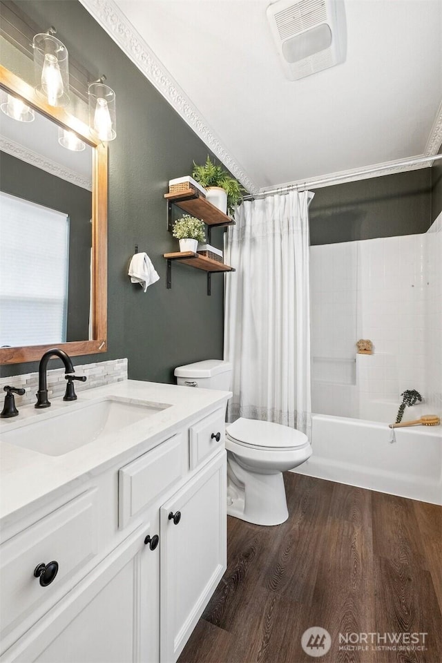 bathroom with visible vents, shower / bathtub combination with curtain, toilet, vanity, and wood finished floors