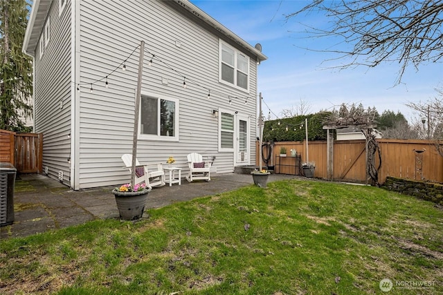 back of property featuring a yard, a fenced backyard, and a patio