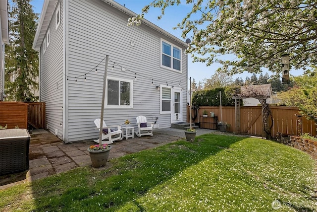 back of property featuring a yard, a patio, and a fenced backyard