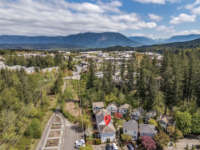 birds eye view of property with a residential view, a wooded view, and a mountain view
